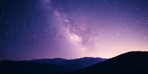 Fototapeta premium Breathtaking view of the milky way galaxy illuminating a night sky with countless stars over a dark mountain range
