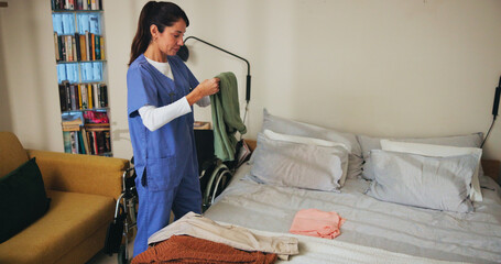 Woman, nurse and fold clothing in home, household tasks and caregiver helping in assisted living....