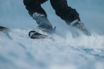 A close-up view of skiing action showing snow being disrupted by the skis in motion, emphasizing the exhilarating experience of outdoor winter sports and the thrill of skiing through powder snow.