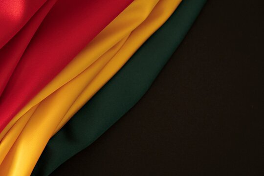Black History Month background. Red, yellow, green colors drapery, silk flag background. Top view