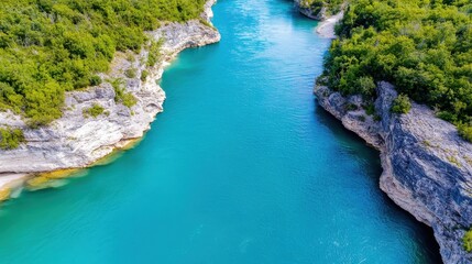 Obraz premium Vibrant blue river winds through lush green cliffs in a tranquil landscape