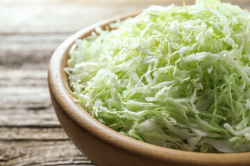 Fresh shredded cabbage on wooden table, closeup