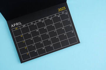 April 2025 Black calendar opening on blue background.