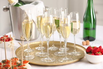 Champagne, strawberries and canapes with red caviar on white table