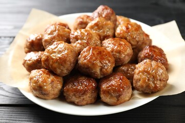 Many delicious meatballs on dark wooden table, closeup