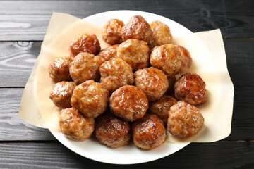 Many delicious meatballs on dark wooden table, closeup