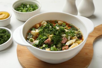 Delicious okroshka soup and ingredients on white table, closeup