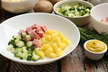 Different ingredients for okroshka soup on wooden table, closeup