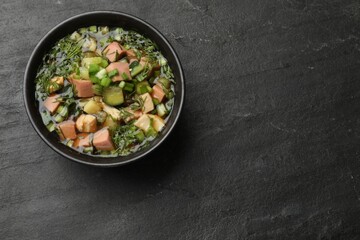Delicious okroshka soup with kvass on black table, top view. Space for text