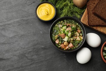 Delicious okroshka soup with kvass and ingredients on black table, flat lay. Space for text