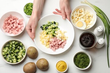 Making okroshka soup. Woman with bowl and different ingredients at white marble table, top view