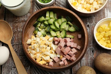 Different ingredients for okroshka soup on wooden table, flat lay
