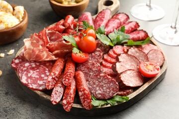 Different smoked sausages slices served on grey table, closeup