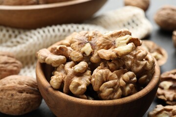 Fresh ripe walnuts in bowl on table, closeup