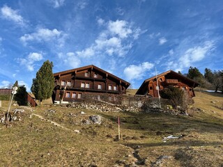 Old traditional swiss rural architecture and alpine livestock farms in the winter ambience over the tourist resort of Engelberg in Swiss Alps - Canton of Obwalden, Switzerland (Kanton Obwald, Schweiz)