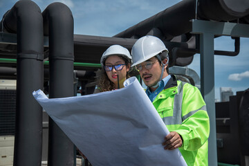 mechanic at work. Two engineer inspects and controls the cooling system of a large factory air...