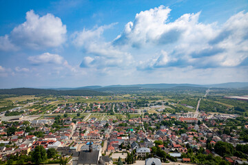 Aerial View of a Lush and Colorful Landscape Featuring Clouds Intermingling with Urban Development