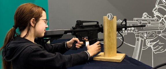 Girl is training shooting with an air rifle