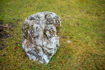Rock formation with texture on green grass in outdoor area