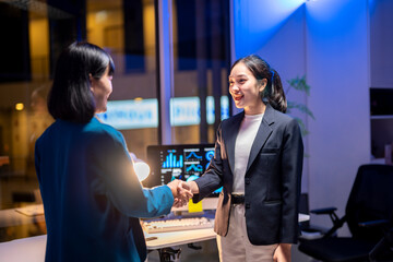 Two women shaking hands in a business setting