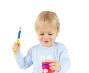 Playful blond child boy painting isolated over transparent background. PNG transparent.