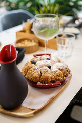 Freshly baked crumble dessert with blueberries and jug on wooden tray