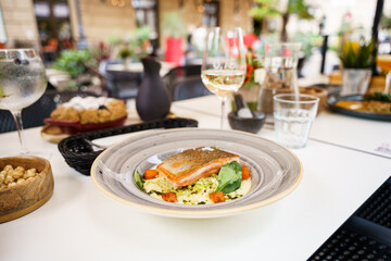 Gourmet grilled salmon dish served in outdoor restaurant setting