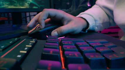 Naklejka premium Frustrated Caucasian blogger male guy modern cyber sport host influencer addict man touch keyboard streamer lose game vlogger playing gaming computer at home upset gamer defeat difficulty neon stream