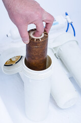 Replacing a dirty, used three-stage water filter cartridge. Used first stage water filter core.