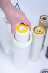 Replacing a dirty, used three-stage water filter cartridge. Used third stage water filter core.