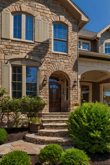 Obraz premium Elegant Stone House Exterior: Modern Architecture and Landscaping Design