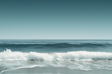 Fototapeta premium Calm ocean waves gently lap at the shore under a clear blue sky during early morning light