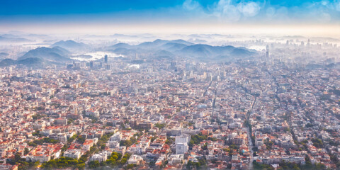 Obraz premium Aerial View of Cityscape with Mountains in the Background.