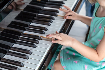 A little boy plays the piano. Music lessons for children, the child learns a musical instrument