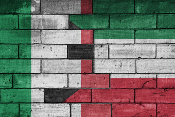 colourful painted big flag of italy and flag of kuwait on a massive old brick wall background. concept