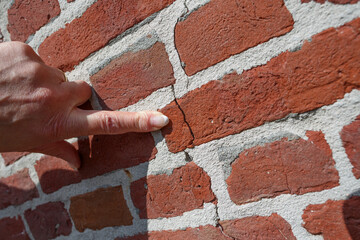 Cracks in the wall due to heavy traffic pressure causing structural issues in urban environment