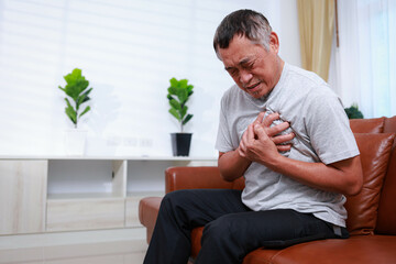 An elderly Asian man has severe heart pain and he needs urgent help. The concept of health care for...