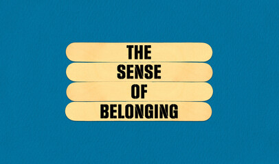 The Sense of Belonging Symbol. Concept word The Sense of Belonging on beautiful wooden stick. Beautiful Blue Chart Paper Background. Business and The Sense of Belonging concept. Copy space