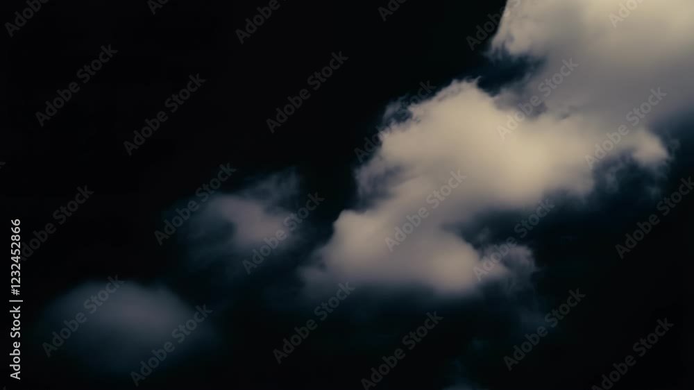 Aufkleber soft white cloud drifting across dark dramatic sky, creating striking visual contrast with deep shad