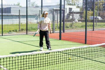 Obraz premium Young sporty woman performing basic strokes during paddle tennis group training