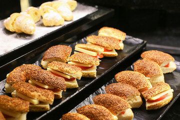 Elegant finger food selection in a luxury restaurant. Mini canapés and gourmet appetizers beautifully arranged on a black background. Exclusive dining experience. Little sandwiches stacked.