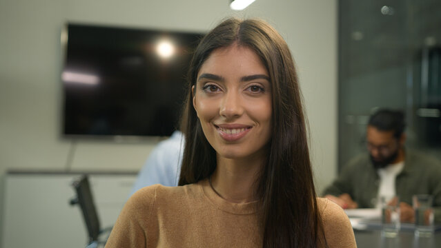 Caucasian woman business portrait Hispanic businesswoman female manager employer investor team leader girl turning head to camera smiling happy cheerful smile indoors office employees work background