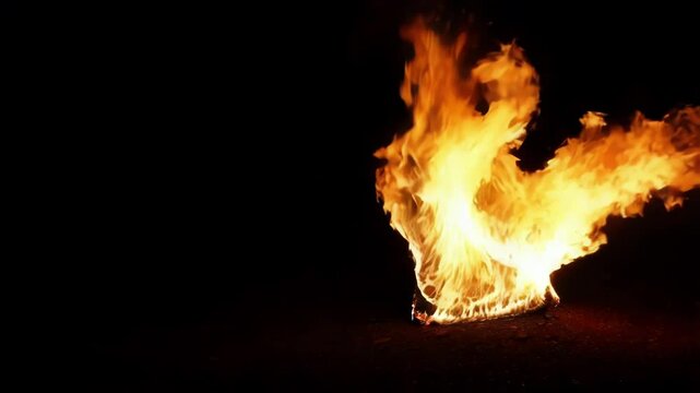Intense orange flames rising from ground against dark backdrop, generating dramatic visual of raw heat and combustive energy