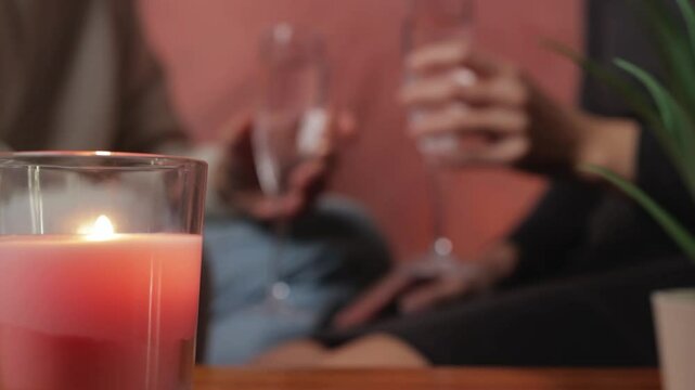 Loving couple sharing intimate candlelit moment, clinking champagne glasses during romantic valentine's day dinner, celebrating togetherness.Celebrating valentine's day or anniversary