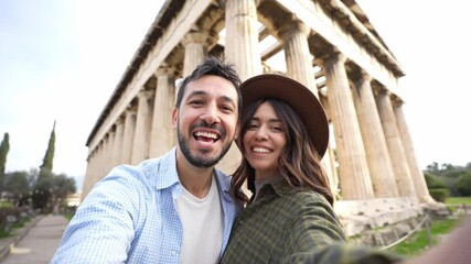 Happy couple in love visiting the Acropolis of Athens, Greece - Smiling boyfriend and girlfriend taking selfie with smart phone mobile on weekend vacation. Travelling and technology concept - Powered by Adobe