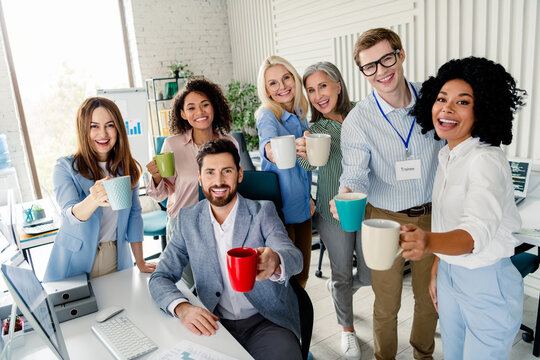 Group of cheerful coworkers enjoying a coffee break together in a modern office setting during a productive workday