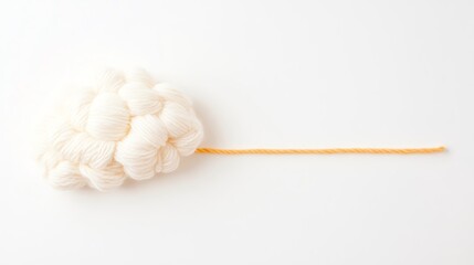 Obraz premium A fluffy, white cotton cloud on a simple background, featuring a thin, orange stick extending from one side.
