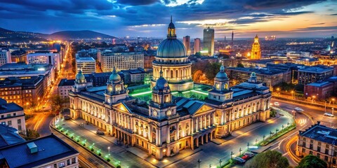 Naklejka premium Aerial drone captures Belfast City Hall's illuminated beauty at night, a breathtaking Co Antrim cityscape.