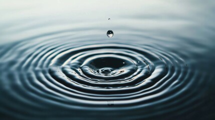 Water drop falling to liquid surface and creating splashes and ripple. Transparent droplet suspended above calm surface. Fluid dynamics and serene simplicity