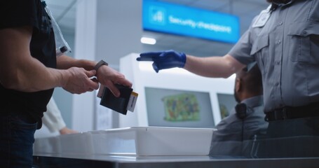 Airport Security Checkpoint during Boarding Flight. Diverse Passengers Put Personal Belongings in...